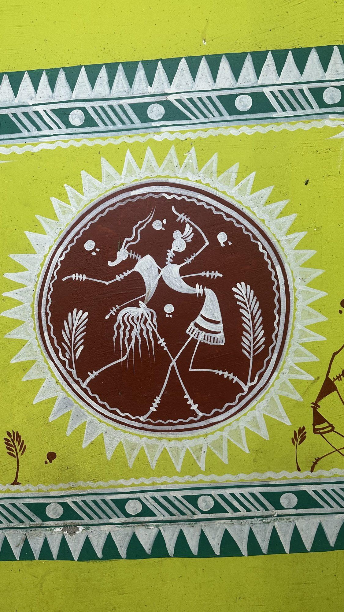 Folk-art wall painting of two dancers in a circle with a white sunburst border on yellow