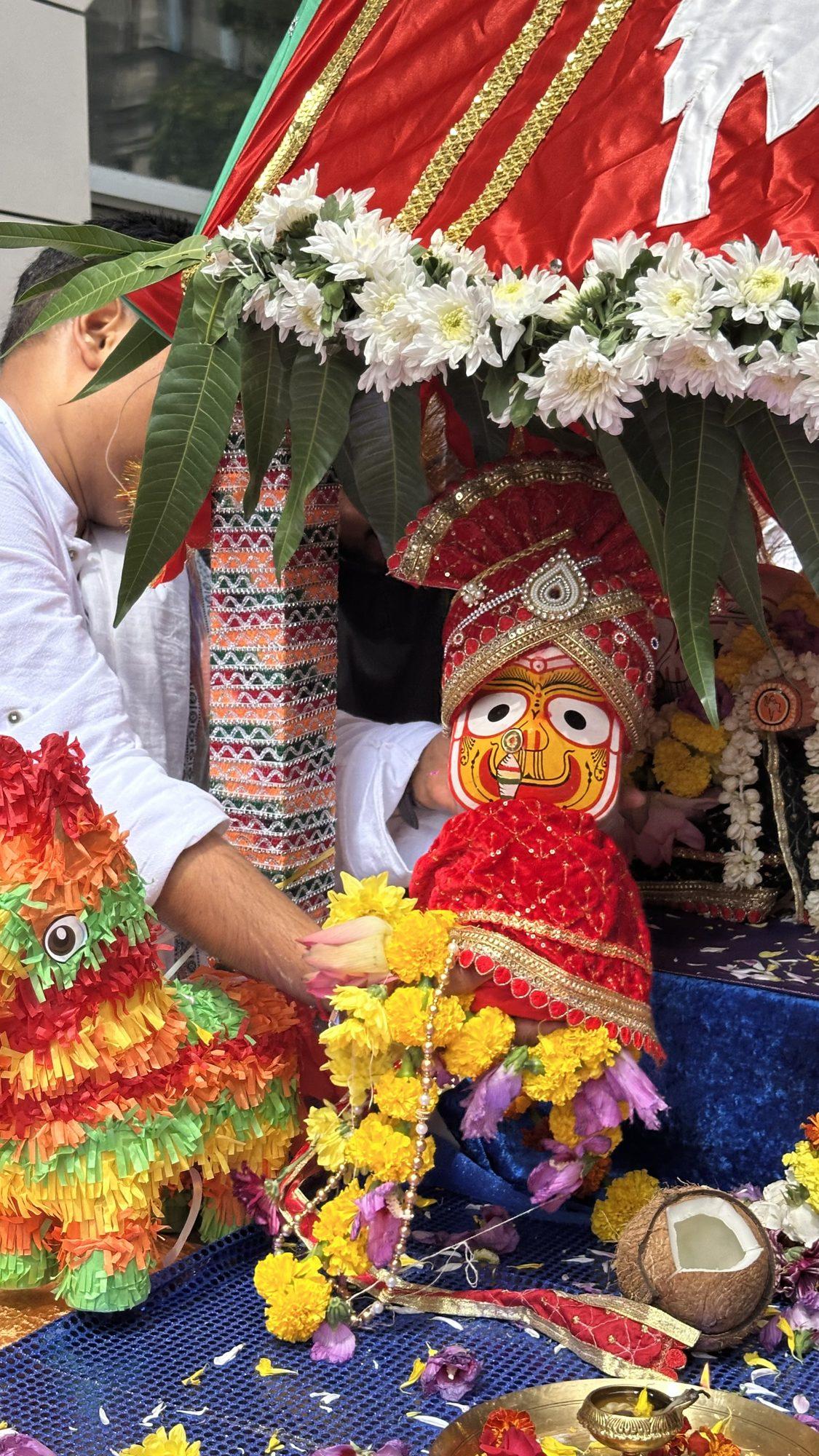 Lord Jagannath on the chariot surrounded by marigold garlands, a coconut and offerings
